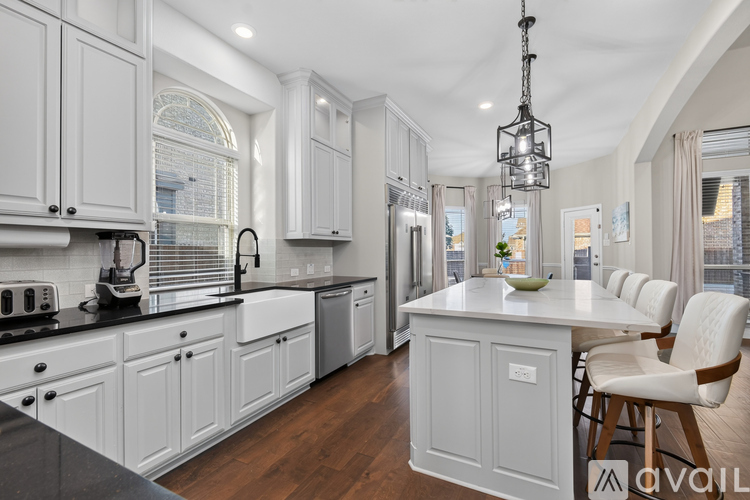 A modern kitchen with white cabinets and a central island.