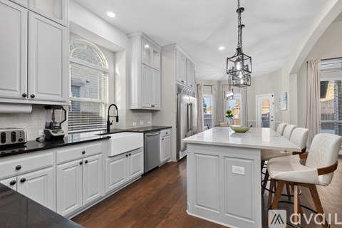 A modern kitchen with white cabinets and a central island.
