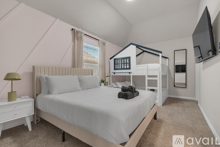 A bedroom with a large bed and a television mounted on the wall.