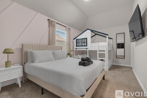 A bedroom with a large bed and a television mounted on the wall.