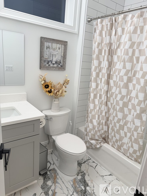 A bathroom with a toilet, sink, and shower curtain.