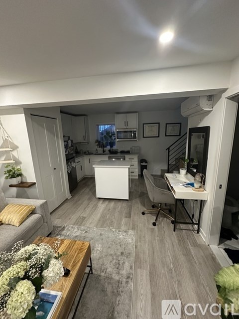 A well-lit kitchen and living room with a dining table and chairs.