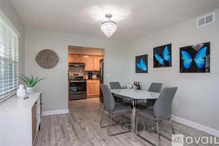 A dining room with a white table and grey chairs.