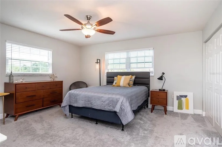 A bedroom with a bed, dresser, and nightstand.