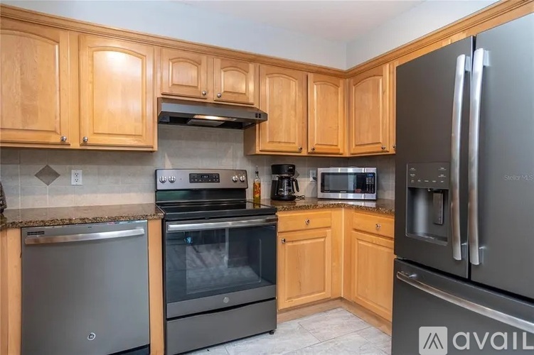 A kitchen with wooden cabinets and stainless steel appliances.