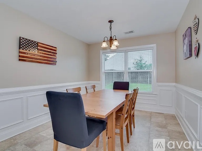 A dining room with a wooden table and chairs.