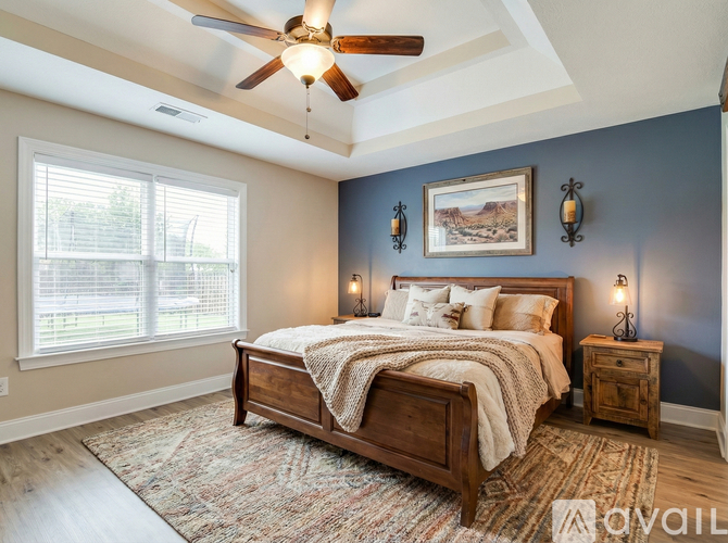 A bedroom with a bed, a ceiling fan, and a rug.