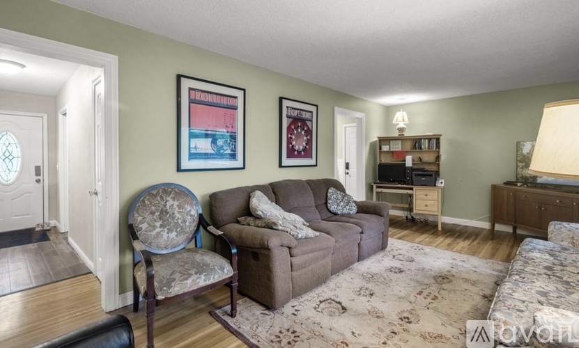 A living room with a brown couch and a chair with a floral pattern.