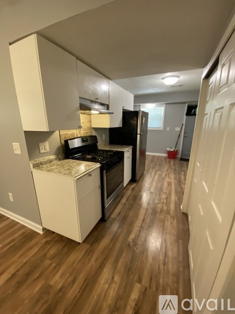 A kitchen with wooden floors and white cabinets.