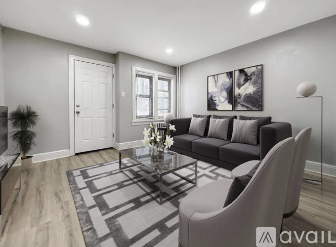 A modern living room with a grey sofa, a coffee table, and a large painting on the wall.