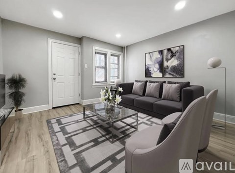 A modern living room with a grey sofa, a coffee table, and a large painting on the wall.