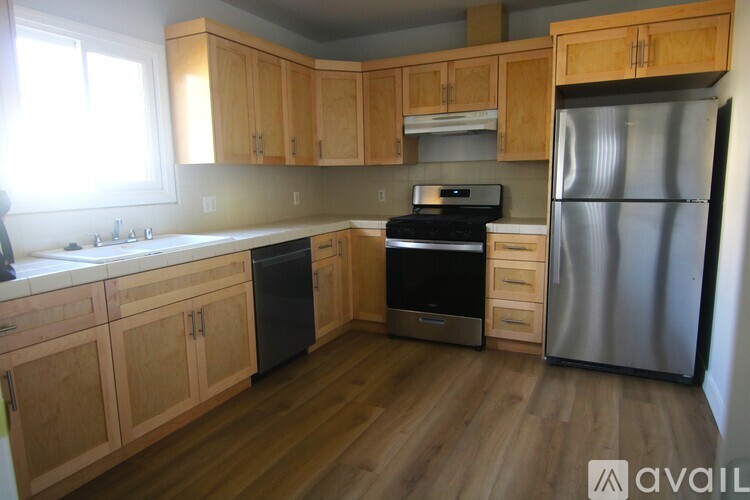 A kitchen with wooden cabinets and a stainless steel refrigerator.