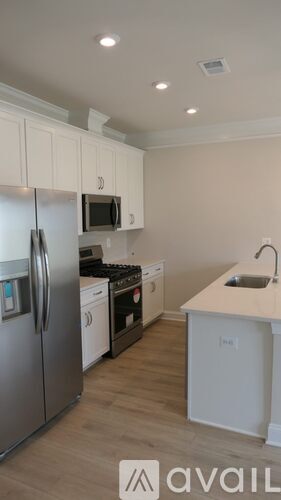 A kitchen with a refrigerator, stove, and microwave.