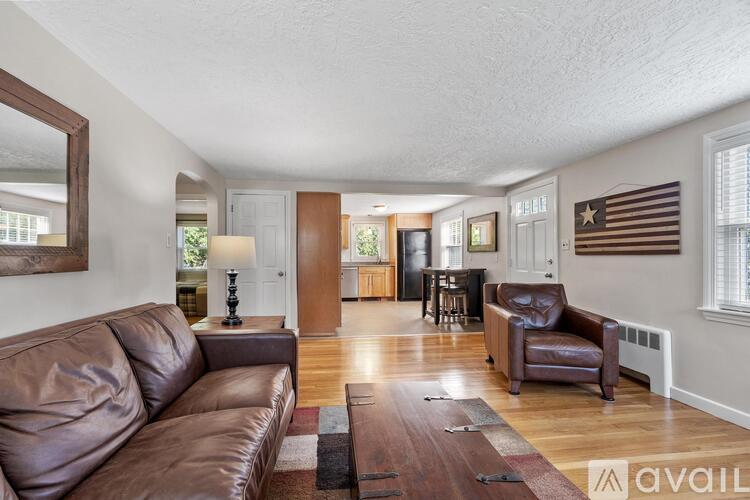 A living room with a brown leather couch and a wooden coffee table.