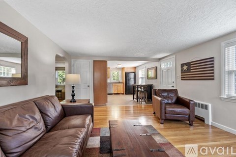 A living room with a brown leather couch and a wooden coffee table.