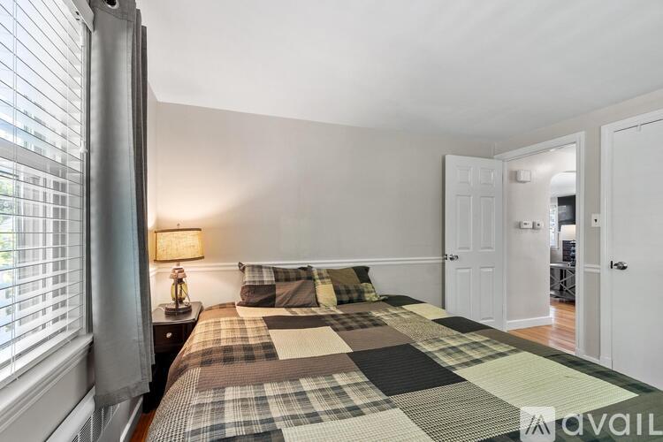 A bedroom with a bed and a lamp on a nightstand.