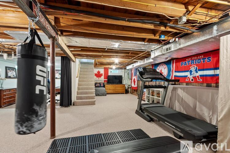 A gym with a punching bag and a treadmill.