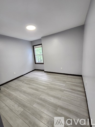 A room with a window and wooden flooring.