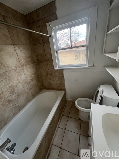 A bathroom with a tub, toilet, and sink.