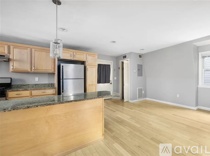 A kitchen with wooden cabinets and a granite countertop.