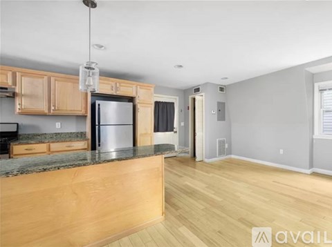 A kitchen with wooden cabinets and a granite countertop.