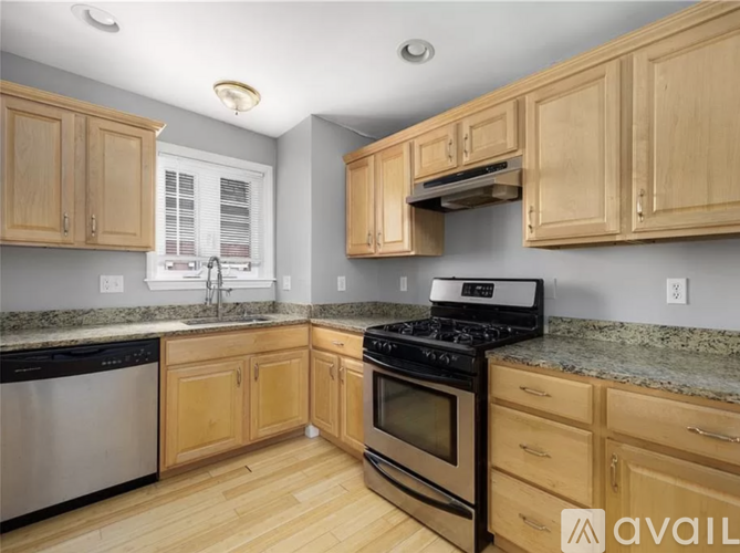 A kitchen with wooden cabinets and a black stove top oven.