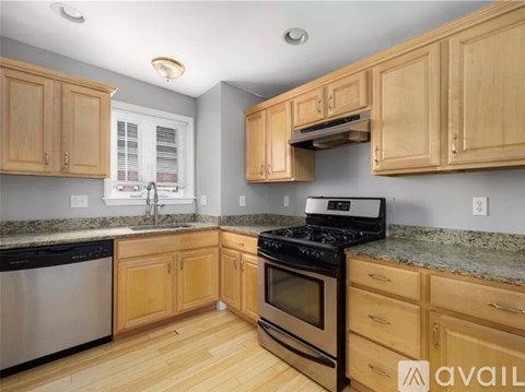 A kitchen with wooden cabinets and a black stove top oven.