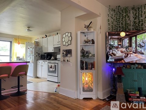 A kitchen with a pink counter and wooden floors.