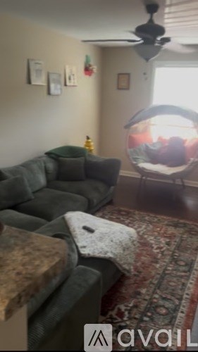 A living room with a grey couch and a fishbowl on the table.