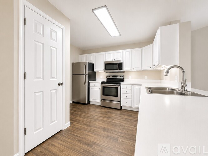 A kitchen with white cabinets and stainless steel appliances.