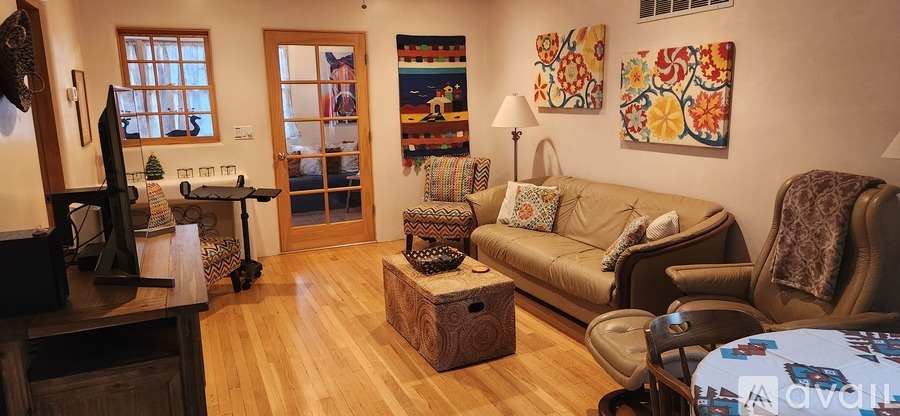 A living room with a couch, chairs, and a coffee table.