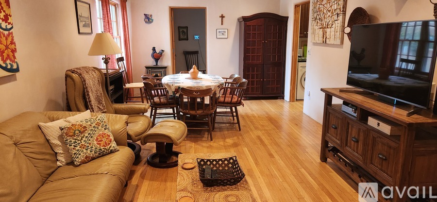 A living room with a brown couch and a wooden floor.