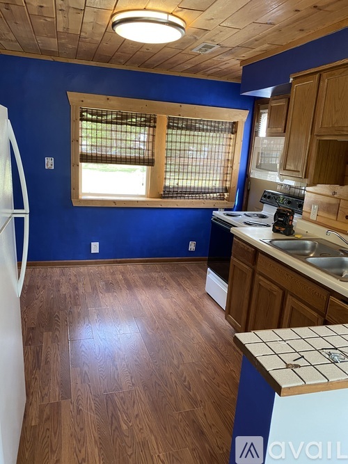 A kitchen with wooden floors and blue walls.