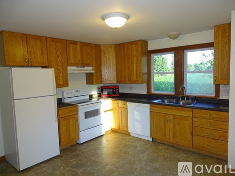 A kitchen with wooden cabinets and a white refrigerator.