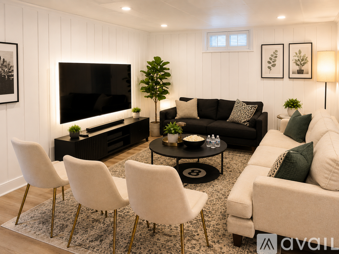 A living room with a black couch, a white couch, and a television on a wooden stand.