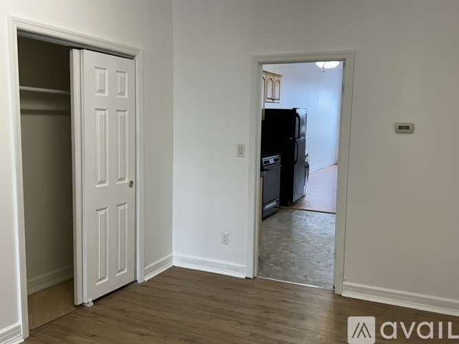 A white door is open to a kitchen.