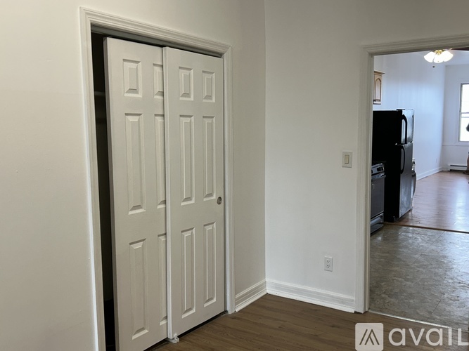 A white door in a room with a wooden floor.
