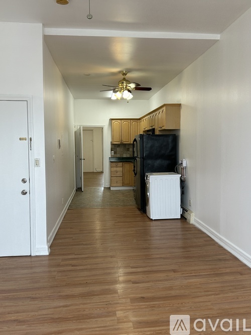 A long hallway with a kitchen area at the end.
