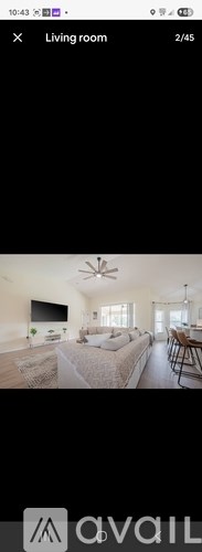 A living room with a couch, a television, and a ceiling fan.