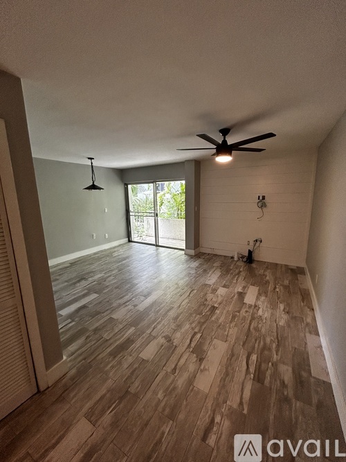 A room with wooden flooring and a ceiling fan.