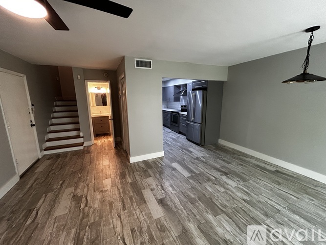 A room with a ceiling fan and a light hanging from the ceiling.