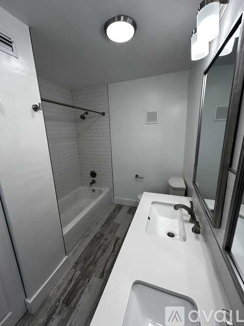 A bathroom with a white sink and a white toilet.