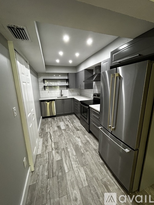 A modern kitchen with stainless steel appliances and a tiled floor.