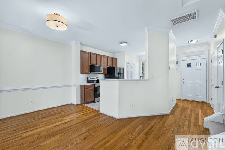 A spacious room with wooden floors and a large window.