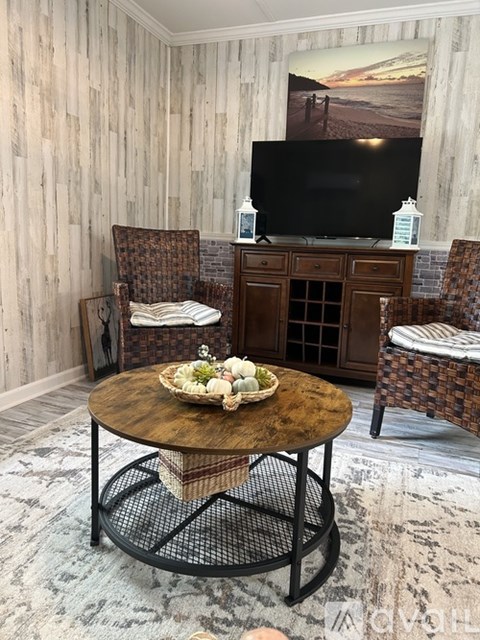 A living room with a wooden wall and a television on a cabinet.