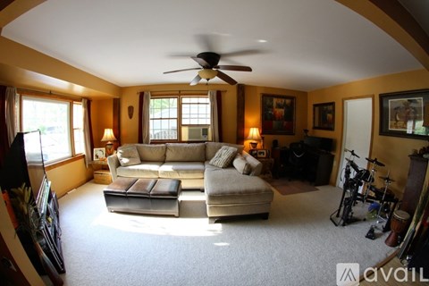 A living room with a white couch and a ceiling fan.