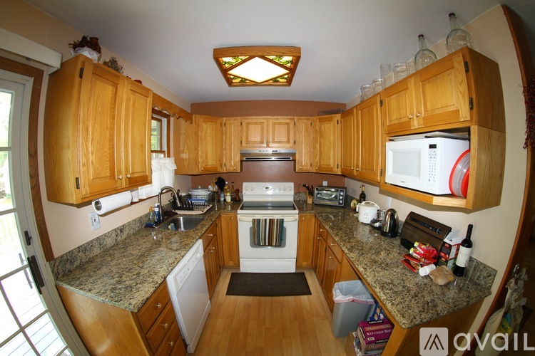 A kitchen with wooden cabinets and granite countertops.