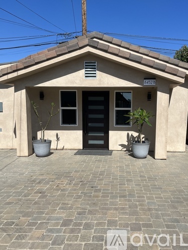 A house with a black door and windows with a small porch.