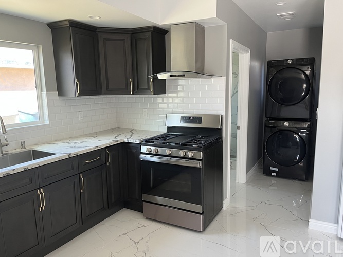 A kitchen with black cabinets and a white tile backsplash.
