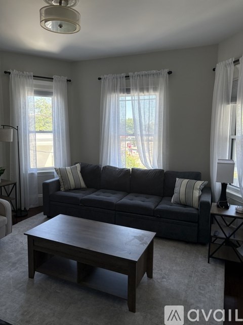 A living room with a grey couch and a wooden coffee table.